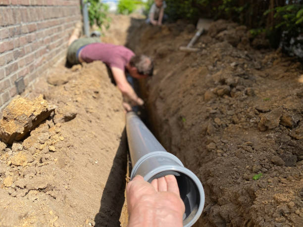 Sewer line replacement in Tillmans Corner. Men laying down a new pipe. Pipe replacement in Tillmans Corner